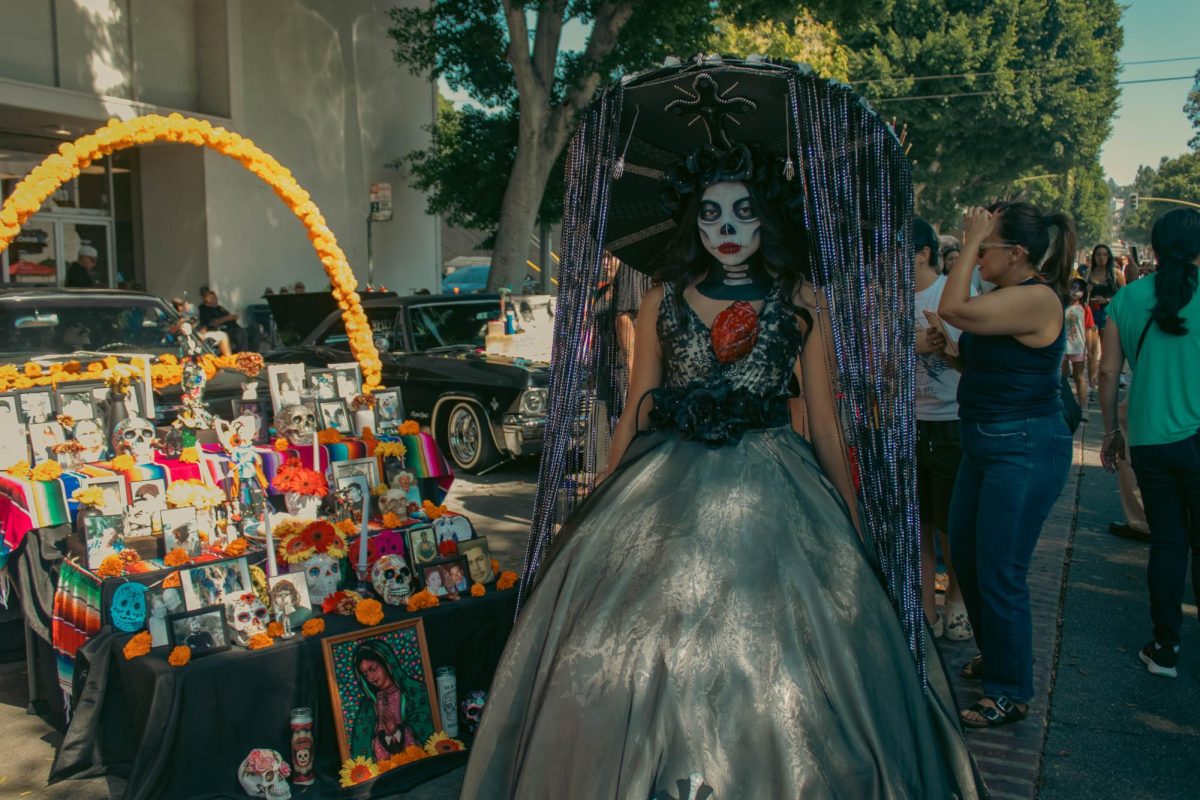 Contestant Jezel Alanis in front of a classic car with an altar. Alanis won first place for the "Catrina" costume contest on October 8 at Uptown Whittier for "Los Muertos" festival. 