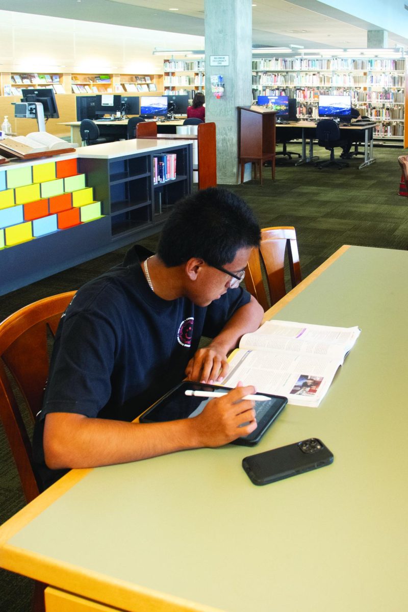 Andres Lopez studying in the RHC libary on a study guide for an EMT course. 
