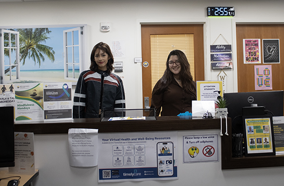 Peer educator Selena Quintero and student worker Naveli Oropeza welcome students at the reception desk in the Student Health and Psychological Services Office located in room SS-230 in the Student Services Building.